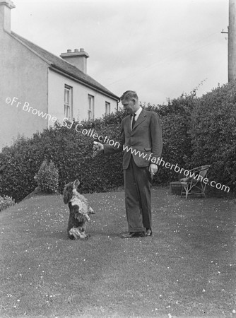 MAN WITH STANDING DOG